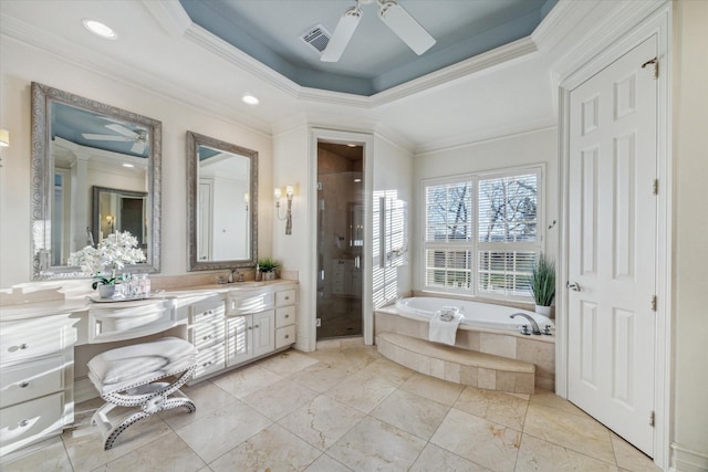 bathroom featuring a stall shower, a tray ceiling, a bath, ceiling fan, and vanity