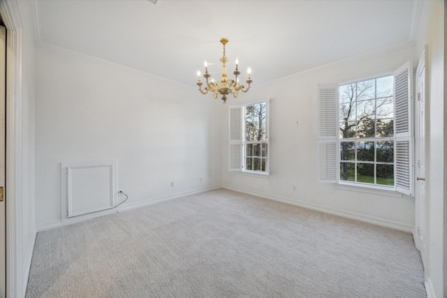 spare room with a chandelier, ornamental molding, baseboards, and carpet floors