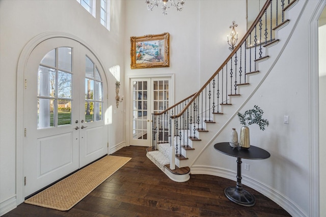 entryway featuring french doors, hardwood / wood-style flooring, a high ceiling, and stairway