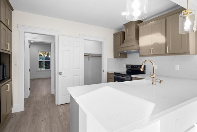 kitchen with custom exhaust hood, light countertops, electric range, light wood-style floors, and a sink