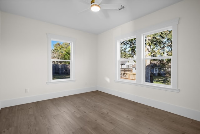 unfurnished room featuring ceiling fan, wood finished floors, and baseboards