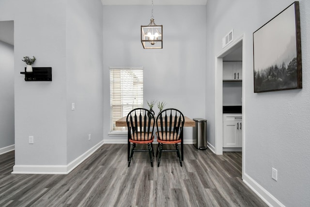 dining space with an inviting chandelier, visible vents, baseboards, and dark wood-type flooring