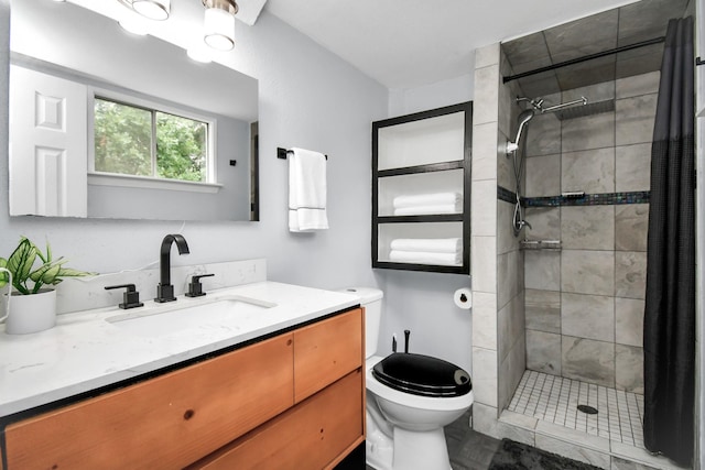 full bathroom with toilet, a stall shower, and vanity