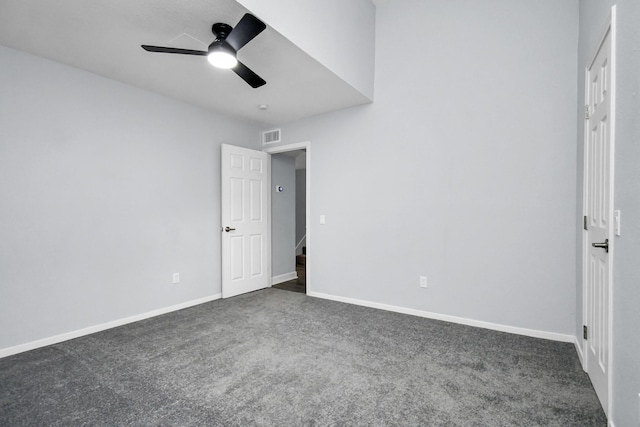 unfurnished bedroom featuring visible vents, baseboards, dark colored carpet, and a ceiling fan