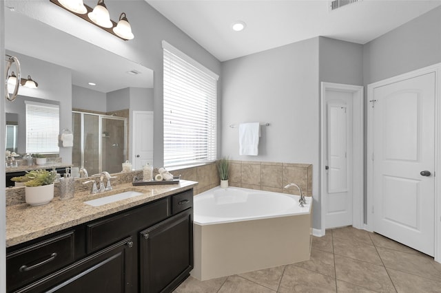 bathroom with a garden tub, a stall shower, tile patterned flooring, and a healthy amount of sunlight