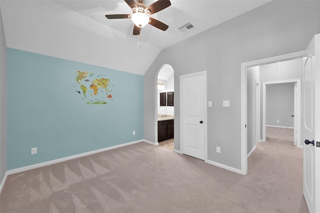 unfurnished bedroom with vaulted ceiling, light colored carpet, visible vents, and baseboards