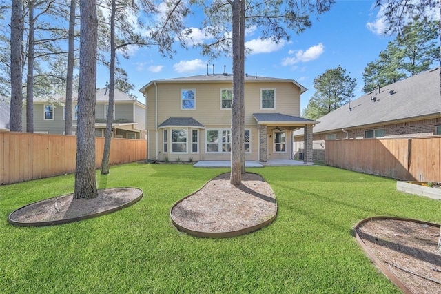 back of property featuring a fenced backyard, a lawn, and a patio