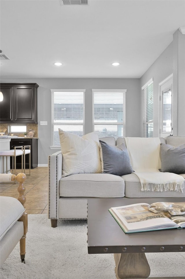 living area with plenty of natural light, light tile patterned flooring, and visible vents