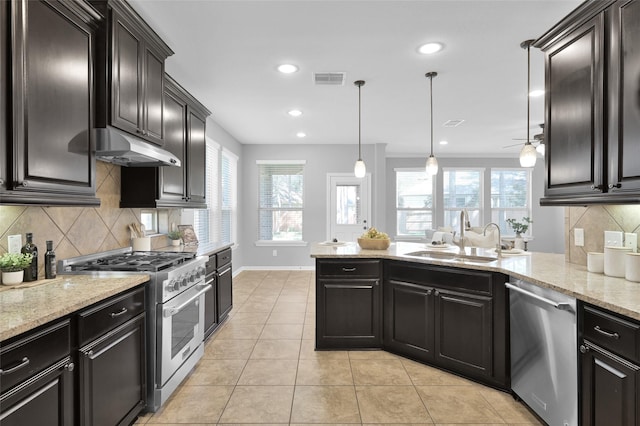 kitchen featuring visible vents, a peninsula, stainless steel appliances, under cabinet range hood, and a sink