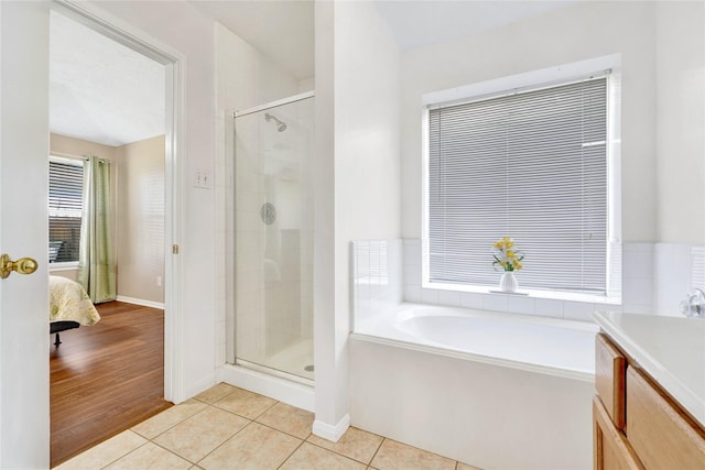 full bath featuring a garden tub, connected bathroom, a shower stall, and tile patterned floors