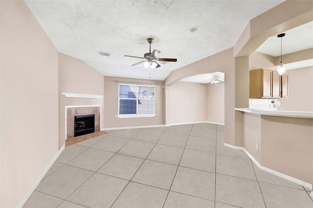 unfurnished living room featuring visible vents, ceiling fan, a textured ceiling, and light tile patterned floors