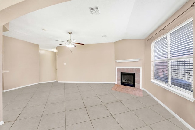 unfurnished living room featuring visible vents, a tiled fireplace, a ceiling fan, light tile patterned flooring, and baseboards