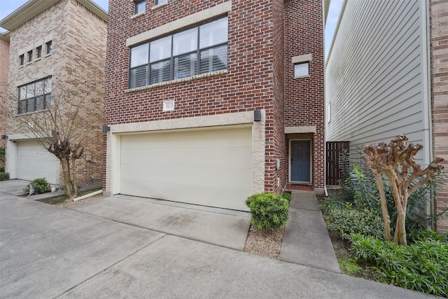 view of front facade with a garage, brick siding, and driveway