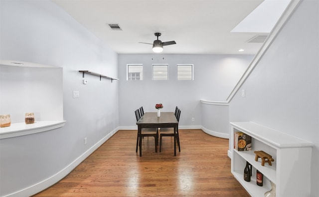 dining area featuring wood finished floors, visible vents, and baseboards