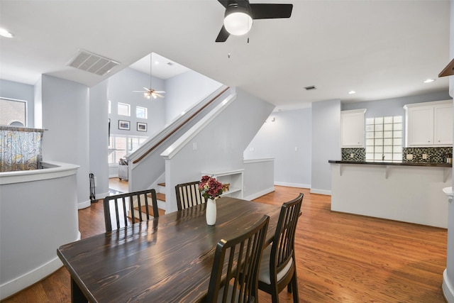 dining area with visible vents, recessed lighting, stairway, and wood finished floors