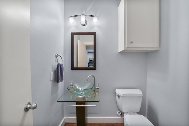 bathroom with a sink, baseboards, and toilet