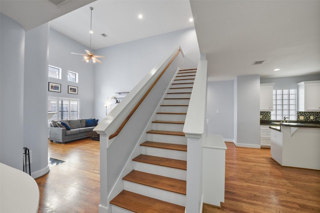 stairs featuring recessed lighting, visible vents, wood finished floors, and a ceiling fan