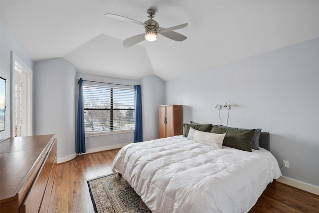 bedroom with light wood finished floors, ceiling fan, baseboards, and lofted ceiling