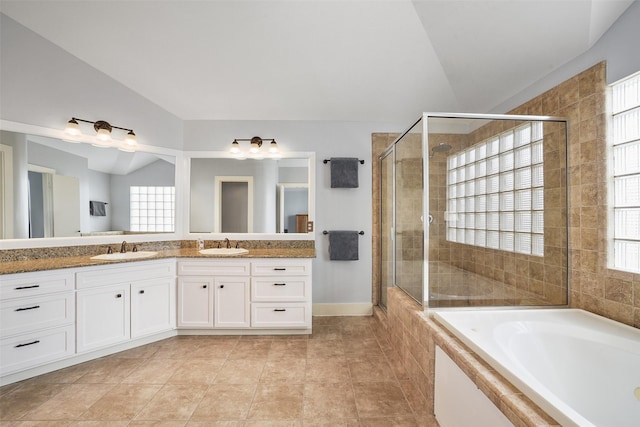 full bathroom with a sink, lofted ceiling, a stall shower, and double vanity