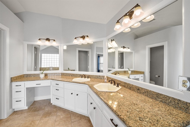 bathroom with vanity, lofted ceiling, toilet, and tile patterned floors