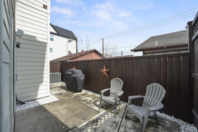 view of patio with area for grilling, central air condition unit, and a fenced backyard