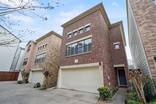 view of front of home with brick siding, driveway, a garage, and fence