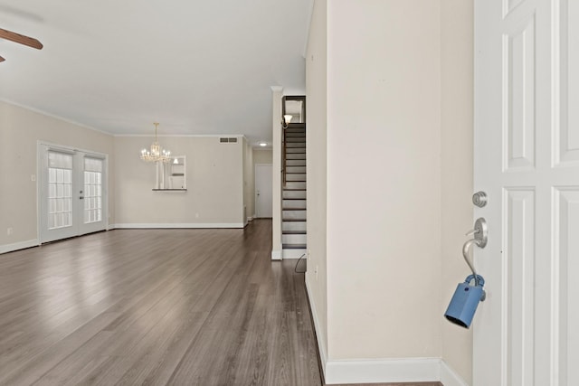 foyer with wood finished floors, baseboards, and stairs