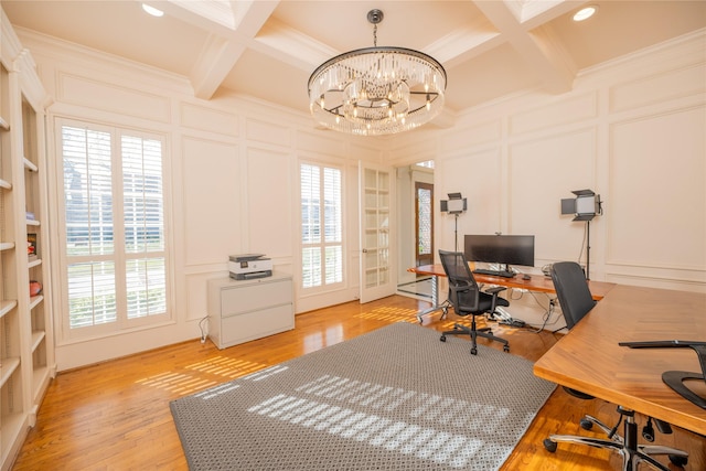 home office featuring beam ceiling, a decorative wall, ornamental molding, light wood-type flooring, and coffered ceiling