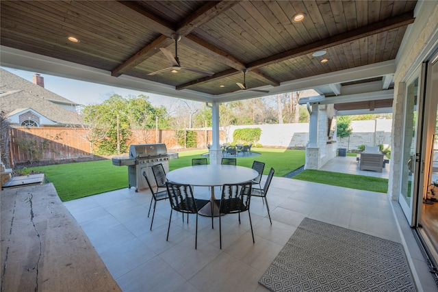 view of patio with outdoor dining space, area for grilling, a fenced backyard, and a ceiling fan