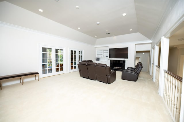 home theater with french doors, a fireplace, lofted ceiling, ornamental molding, and light carpet