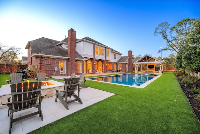 view of pool with a fire pit, a patio, a yard, and a fenced backyard