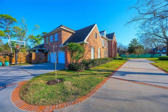 view of property exterior featuring brick siding, a yard, concrete driveway, an attached garage, and fence