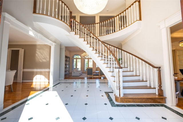 foyer with an inviting chandelier, a high ceiling, baseboards, and stairway