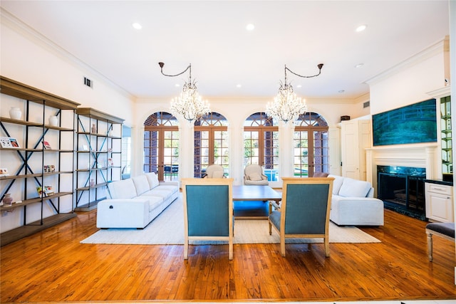 dining area featuring an inviting chandelier, a premium fireplace, visible vents, and french doors