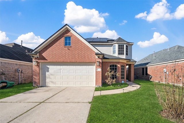 traditional home featuring driveway, roof mounted solar panels, a front yard, an attached garage, and brick siding