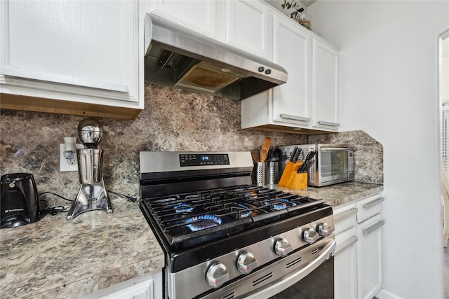 kitchen with light countertops, white cabinets, under cabinet range hood, stainless steel gas stove, and backsplash