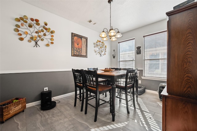 dining space featuring visible vents, an inviting chandelier, and baseboards