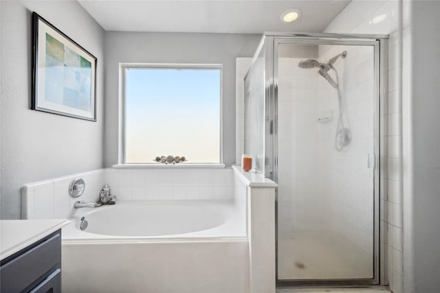 bathroom featuring a stall shower, a bath, and vanity