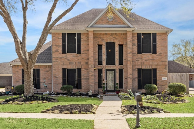 view of front of home featuring a shingled roof and brick siding