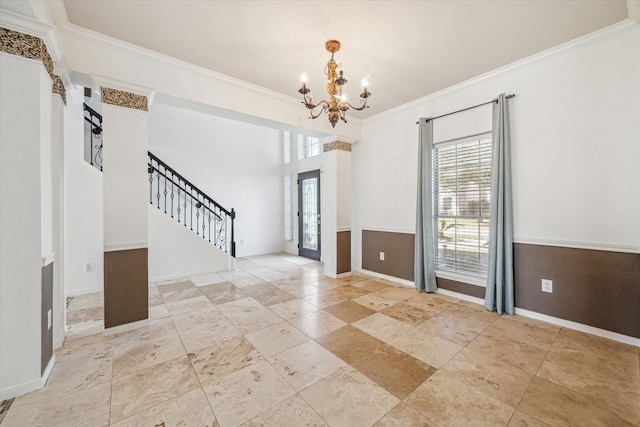 spare room featuring baseboards, stairs, a chandelier, and ornamental molding