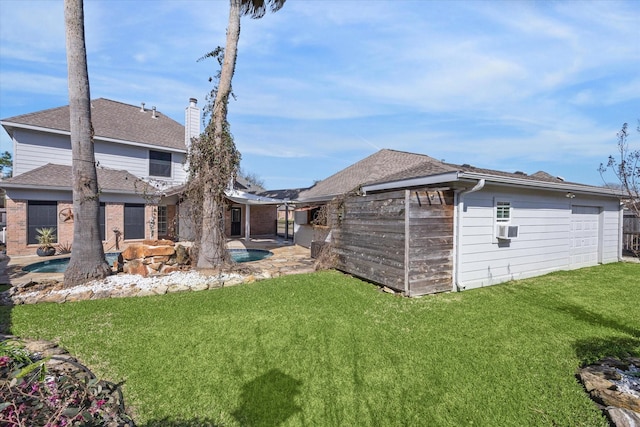 rear view of house featuring roof with shingles, a lawn, a patio area, and a fenced in pool