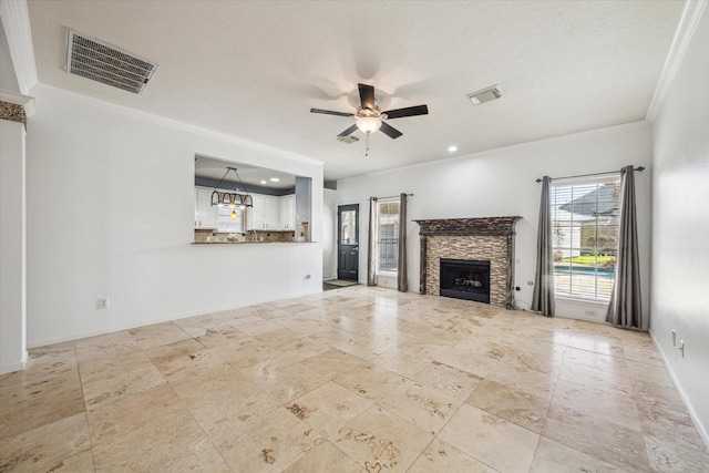 unfurnished living room featuring ceiling fan, a fireplace, visible vents, and baseboards