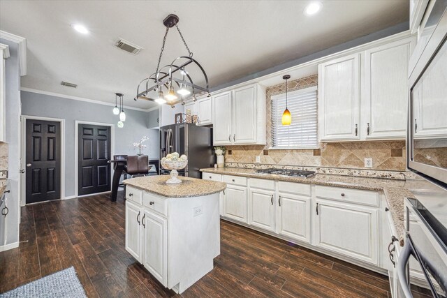 kitchen with stainless steel appliances, dark wood-style flooring, white cabinetry, and backsplash