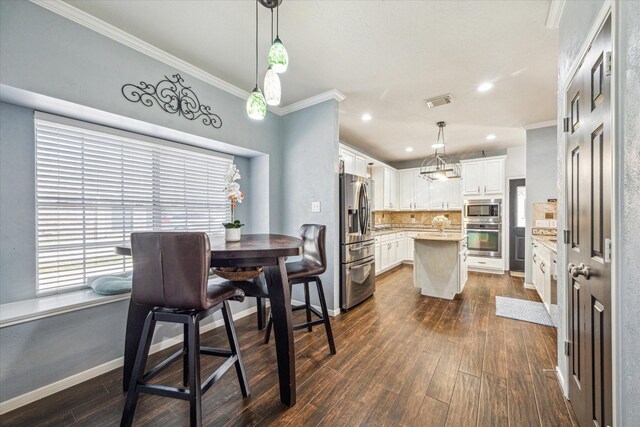 kitchen featuring stainless steel appliances, light countertops, a center island, dark wood finished floors, and crown molding