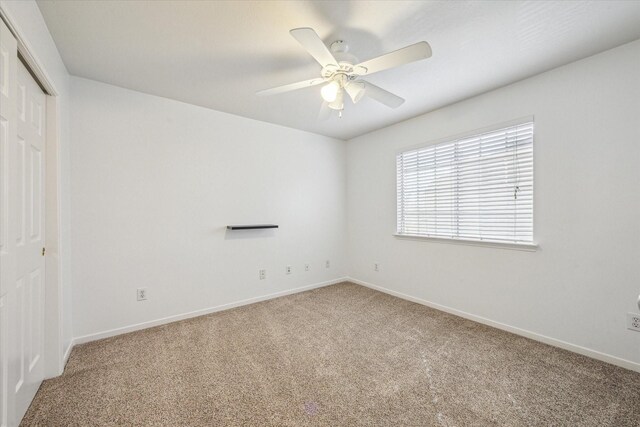 spare room with carpet, baseboards, and ceiling fan