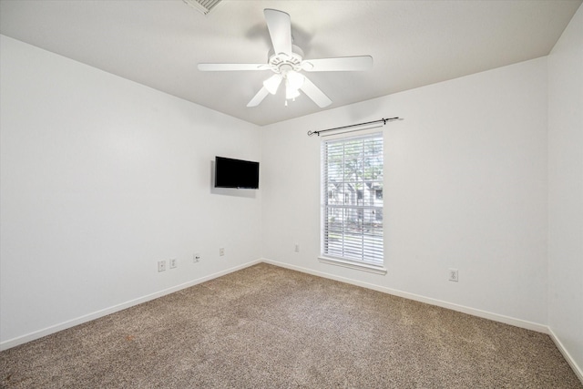 carpeted empty room featuring ceiling fan, visible vents, and baseboards