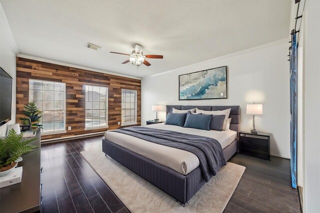 bedroom with visible vents, ornamental molding, dark wood-type flooring, a ceiling fan, and wooden walls