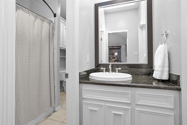 bathroom featuring tile patterned flooring, a shower with shower curtain, toilet, and vanity