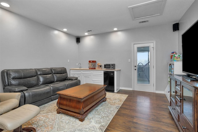 living room featuring visible vents, wet bar, attic access, recessed lighting, and dark wood-type flooring