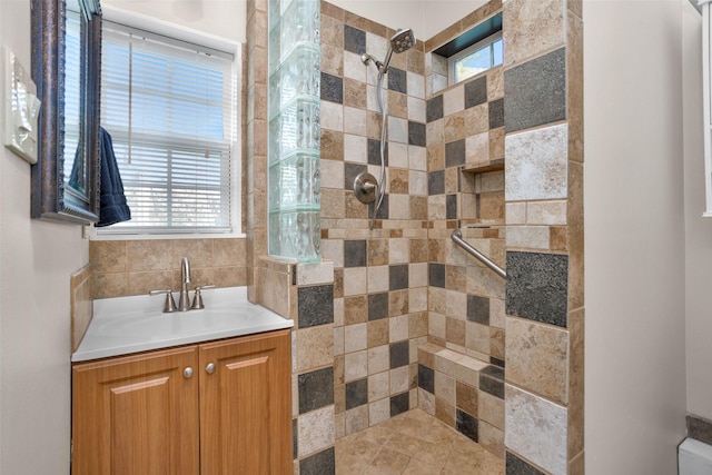 full bathroom featuring a tile shower and vanity